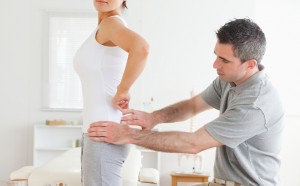 Chiropractor examining a charming woman's back